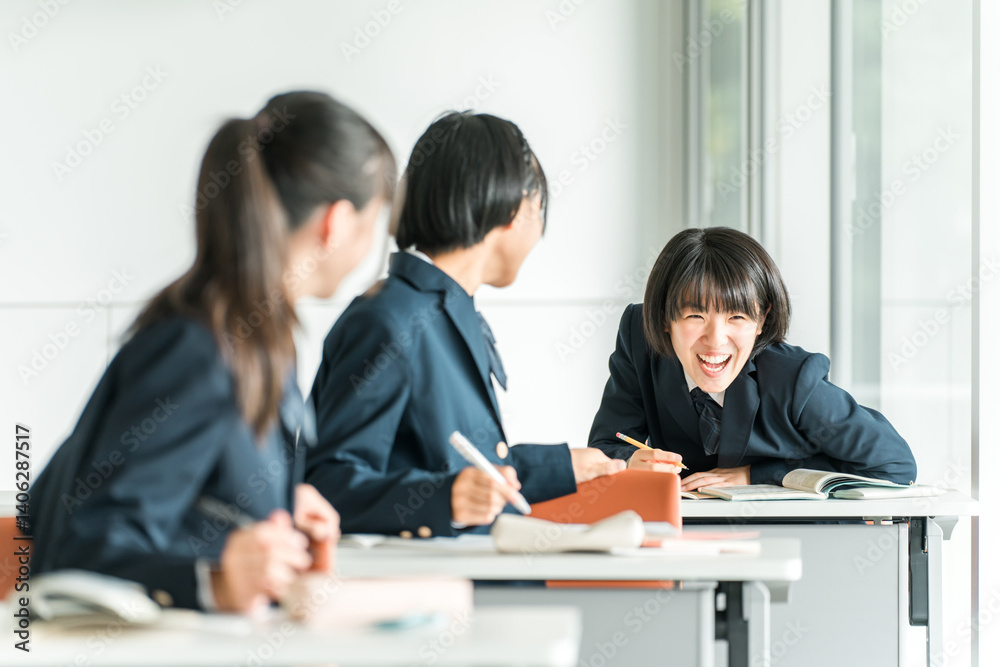 学校で授業中に後ろの席の生徒と話す小学生・中学生・高校生・女子高生（友達）
