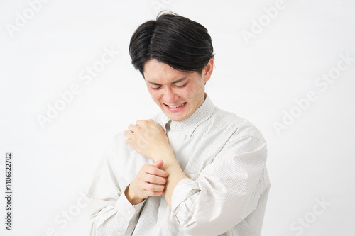 男性　腕を掻く　白背景