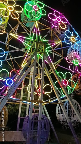 Vibrant ferris wheel featuring colorful at an amusement park. Vertical video.