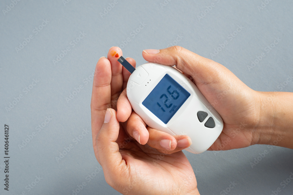 Fototapeta premium Woman's hands checking diabetes and hyperglycemia with digital blood sugar meter. Healthcare and medical concept 