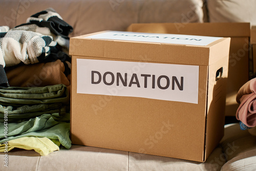 Obraz na płótnie Donation boxes in living room. Packed cardboard boxes full of clothes and toys on couch. Concept of charity, social care and volunteering w salonie
