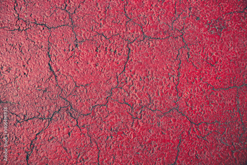 Cracks and lines on the red cement floor tell a story of time.