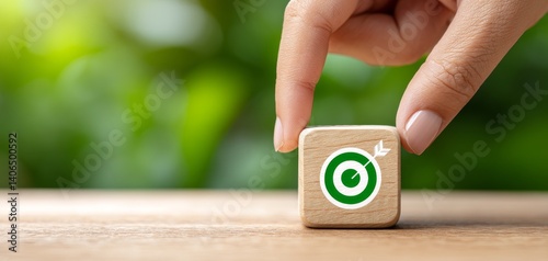 Business Hand Placing Wooden Block with Target Icon on Table for Goal Setting Concept