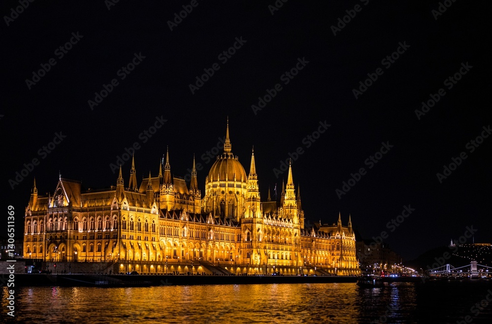 Fototapeta premium Night view of the Hungarian Parliament Building reflecting on the Danube River in Budapest.