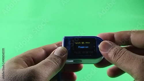 Pulse Oximeter portable digital device to measure person's oxygen saturation. Reduction in oxygenation is an emergency sign of pneumonia requiring urgent hospitalization. green background