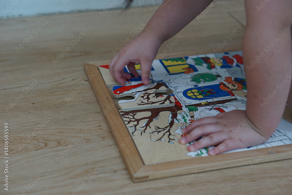 Obraz premium Child playing with wooden puzzle on the floor