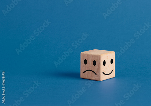 Wooden cube showing happy and sad faces expressing opposite emotions