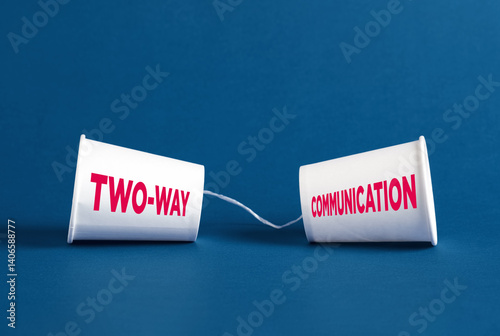 Two-way communication concept represented by plastic cups and string on blue background