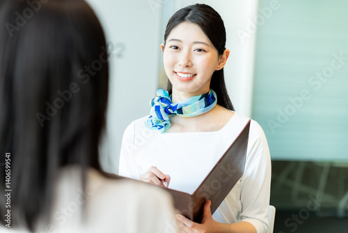 受付の若い女性【撮影協力：学校法人電波学園　東京電子専門学校】