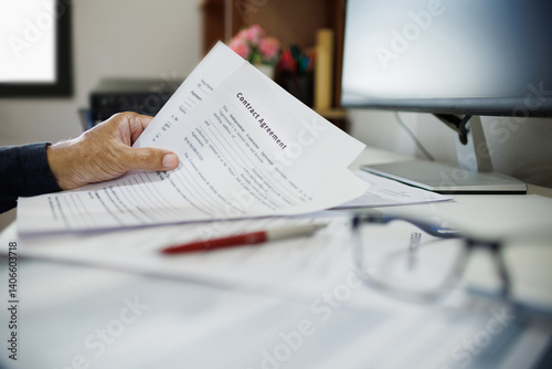 asian businessman reviewing contract document at office. legal expert, professional lawyer working with computer reading and checking financial documents and business contract, close up shot