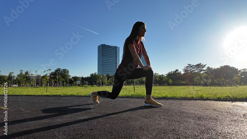 Obraz na płótnie Young woman stretching after exercise and jogging in urban park during sunny summertime day.. w salonie