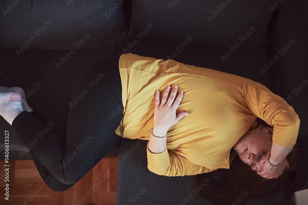 Woman with strong stomach ache, menstrual and digestive issues at home.