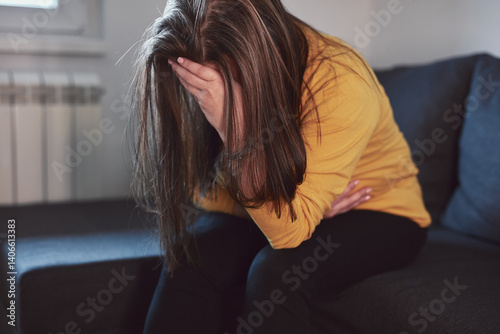 Woman with strong stomach ache, menstrual and digestive issues at home.