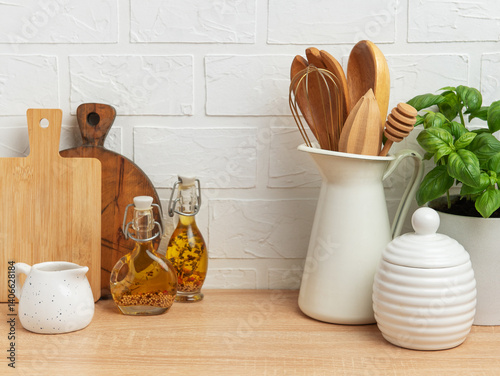 Obraz na płótnie Kitchen utensils, basil plant and condiments resting on wooden countertop in front of white brick wall w salonie