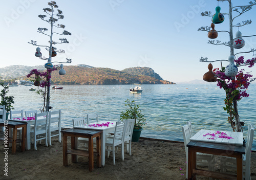 Fototapeta Naklejka Na Ścianę i Meble -  The quaint Gumusluk beach in the holiday town of Bodrum. Coastal street and restaurants