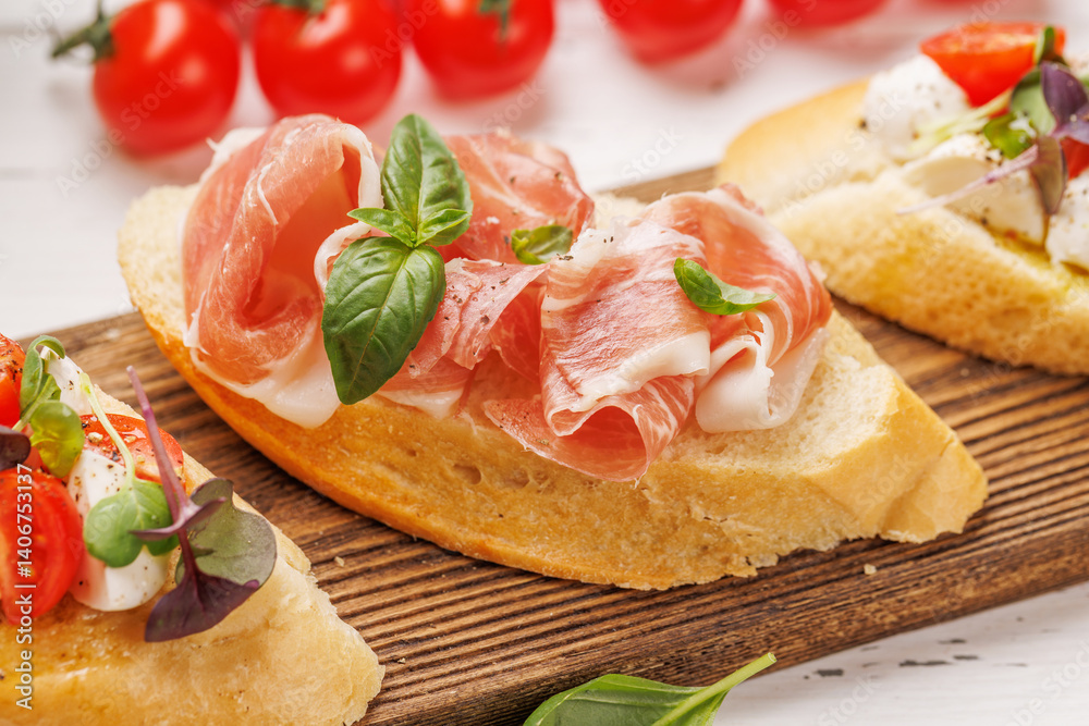 Tasty antipasto toasts featuring classic caprese with mozzarella and tomatoes, and savory prosciutto with herbs Tasty antipasto toasts featuring classic caprese with mozzarella and tomatoes, and savory prosciutto with herbs
