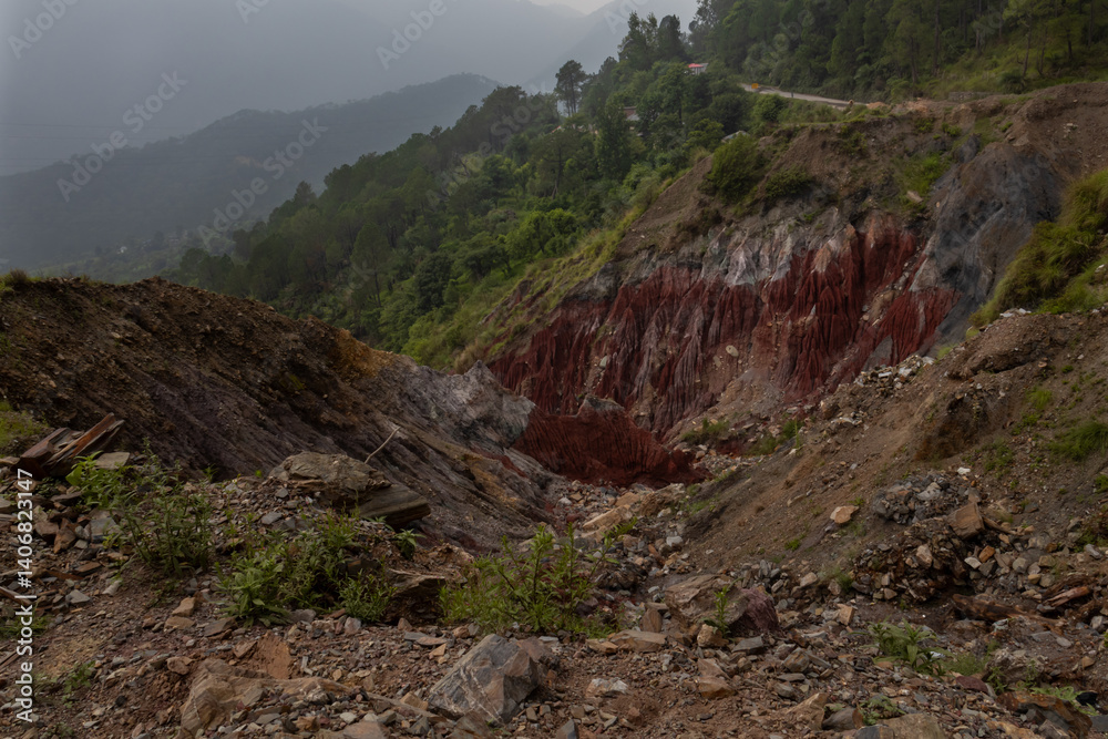 Obraz premium A striking view of red rock formations sculpted by monsoon erosion in the natural hills of Himachal Pradesh, India.