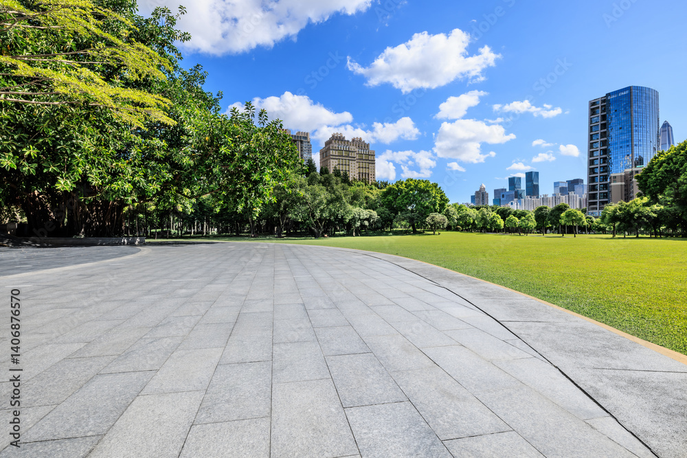Tranquil city park with green lawn and modern buildings under blue sky