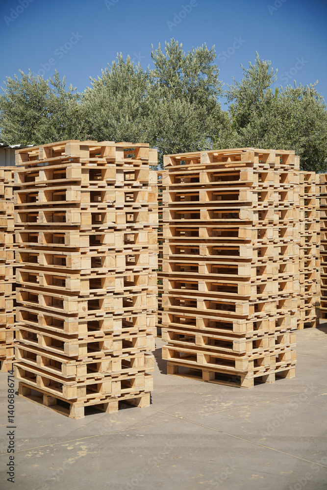 Stacked Wooden Pallets Outdoors in a Storage Facility on a Sunny Day. Stacked Wooden Pallets Outdoors in a Storage Facility on a Sunny Day.