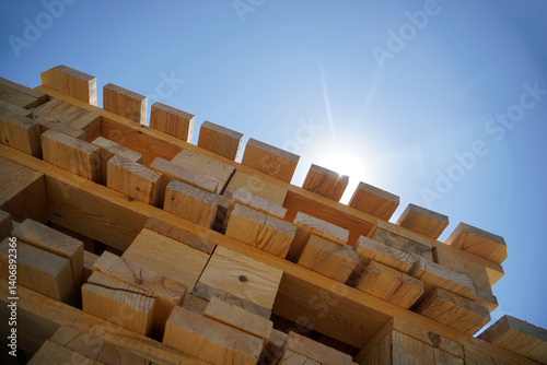 Obraz na płótnie Stack Of Wooden Palette Blocks Against Bright Blue Sky With Sunlight w salonie