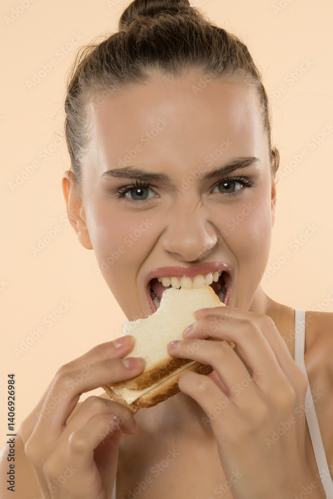 Energetic woman devours sandwich with intense, greedy bite, expressing pure culinary enjoyment Energetic woman devours sandwich with intense, greedy bite, expressing pure culinary enjoyment