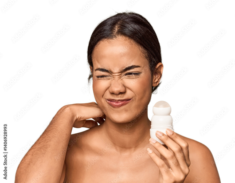 Filipino woman holds deodorant in studio touching back of head, thinking and making a choice. Filipino woman holds deodorant in studio touching back of head, thinking and making a choice.