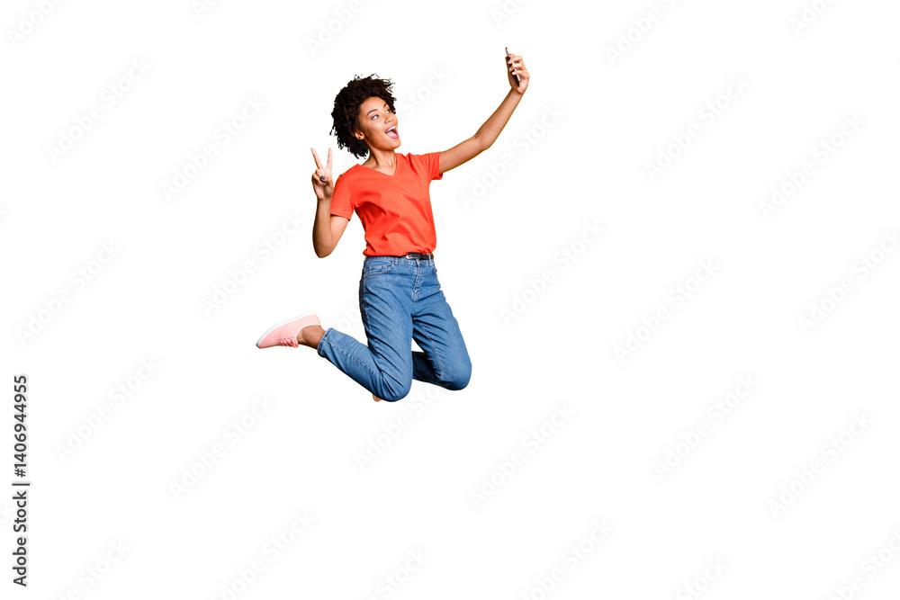 Full size photo of crazy beautiful funky curly hair girl blogger jump use smartphone take selfie make v-signs wear red t-shirt denim jeans sneakers isolated over yellow bright color background Full size photo of crazy beautiful funky curly hair girl blogger jump use smartphone take selfie make v-signs wear red t-shirt denim jeans sneakers isolated over yellow bright color background