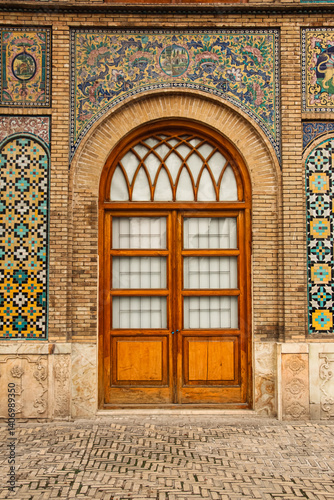 Iranian tile design, wooden door, Old wooden door with colorful tiles, Persian architecture with tile and wood, Historic door framed with tiles, Colorful wall with vintage wooden door