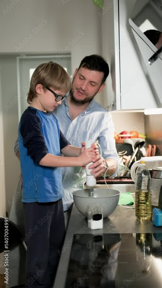custom made wallpaper toronto digitalBoy in glasses mixing pancake batter with his father on his kitchen. Vertical. Medium long shot. Slow motion
