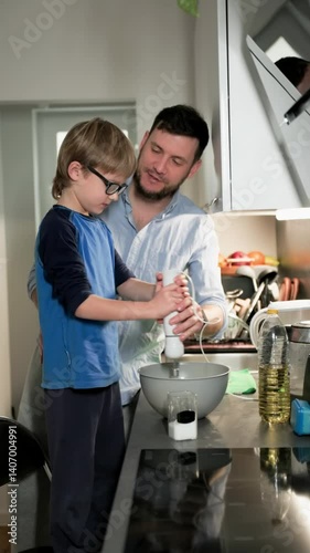 Wallpaper Mural Boy in glasses mixing pancake batter with his father on his kitchen. Vertical. Medium long shot. Slow motion Torontodigital.ca