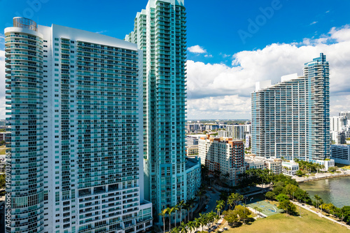 Close-up drone view of high-rise residential towers in Miami’s Edgewater neighborhood, surrounded by lush parks and modern development.