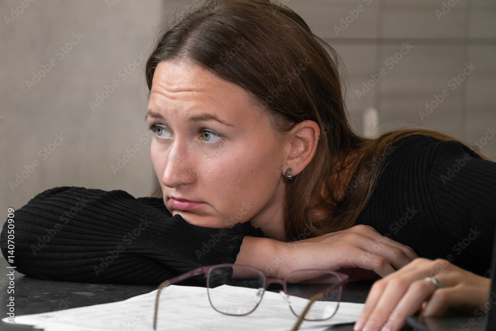 Exhausted businesswoman lies at her desk after a long day of working on her laptop, struggling with fatigue and burnout in the modern workplace