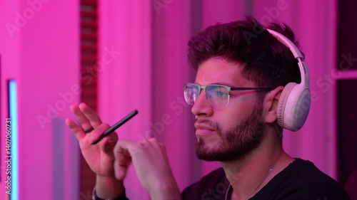 A focused individual analyzes data on dual monitors in a cozy home environment, illuminated by vibrant ambient lights, creating a productive atmosphere.