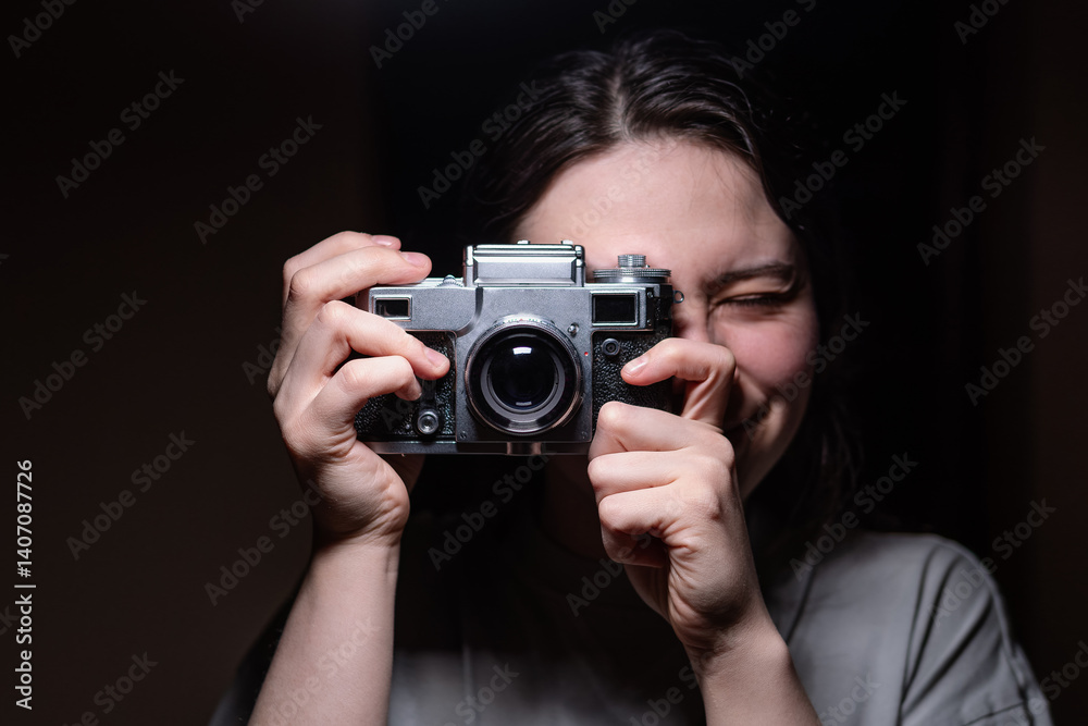Girl holding a camera on a black background Girl holding a camera on a black background