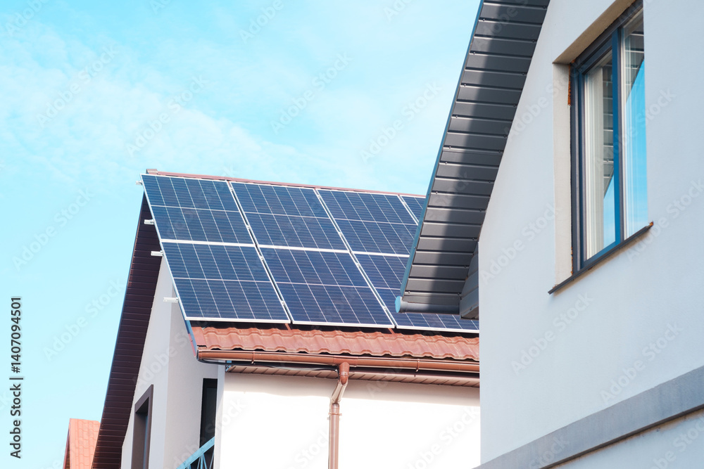 Fototapeta premium Solar panels installed on houses in a residential area with clear blue skies