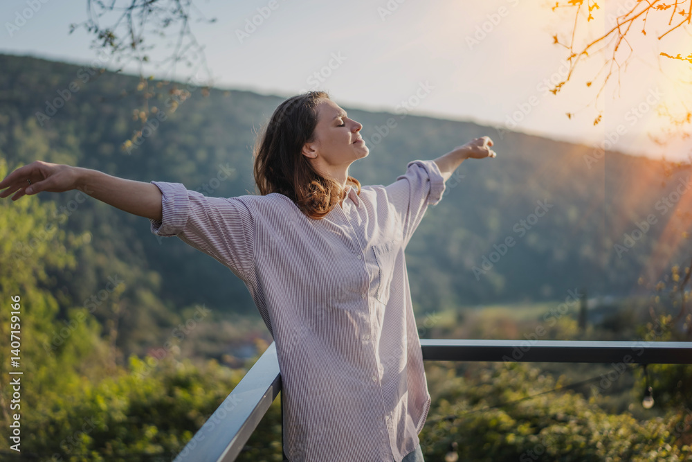 Young woman relaxing and enjoying nature view from terrace
