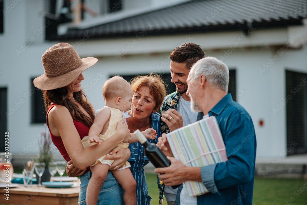 © Halfpoint - Parents welcoming their son, daughter-in-law, and baby at a family barbecue. © Halfpoint - Parents welcoming their son, daughter-in-law, and baby at a family barbecue.