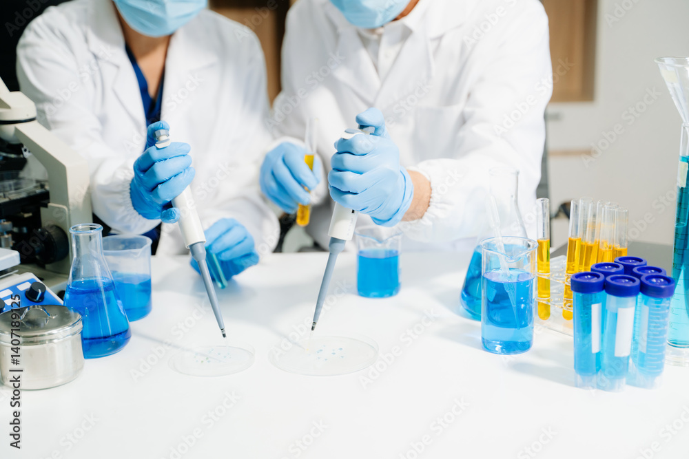 Fototapeta premium Two scientists in a high-tech lab analyzing biochemical samples, using micro pipettes
