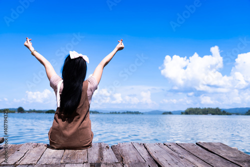 Young woman by the lake in a bright morning with a cloudy sky
