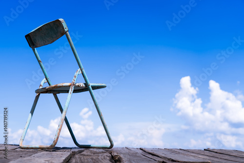 A chair by the lake in a bright morning with a cloudy sky