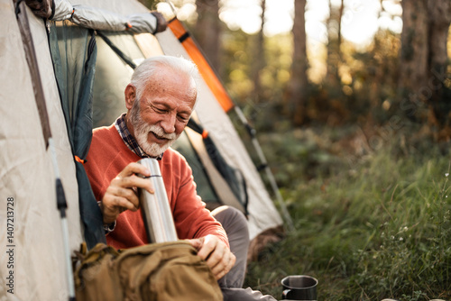 Senior Man Enjoying Tea by Tent During Peaceful Camping Trip