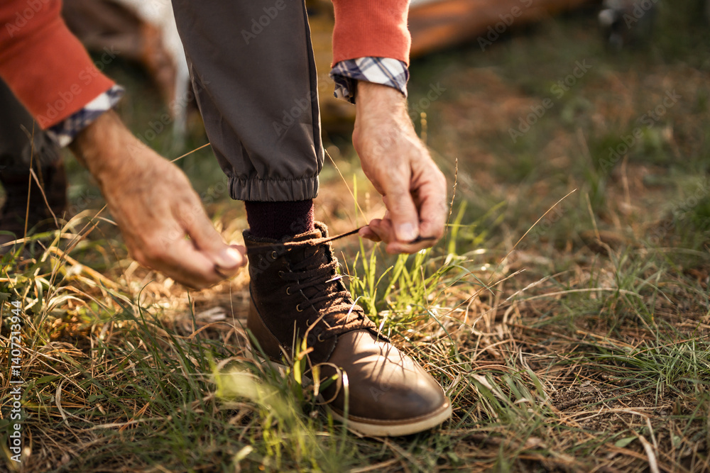 Close-Up of Man Tying Hiking Boot in Outdoors Setting