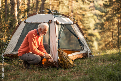 Obraz na płótnie Senior Man Camping in a Forest with Tent Setup w salonie