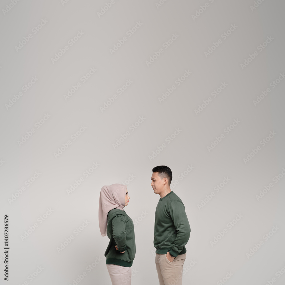 Happy muslim couple , smiling, leaning on each other wearing green casual wear. elegant photo with white ivory color background isolated. studio shot. Happy muslim couple , smiling, leaning on each other wearing green casual wear. elegant photo with white ivory color background isolated. studio shot.