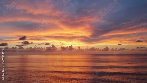 Glorious sunset over the ocean horizon with dramatic clouds and reflections on the water's surface