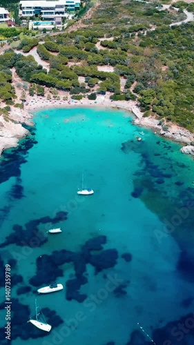 Vertical video of the beach - people swimming and sunbathing, vacation, sun loungers, 4k video of the beach and the sea shot by drone