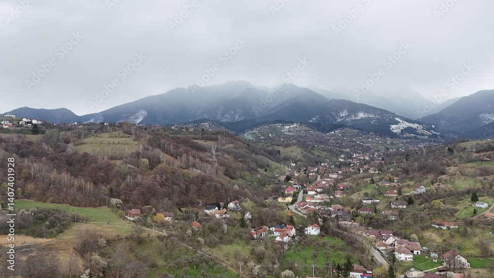 Obraz premium Beautiful drone picture of the Bran village, Transylvania, Romania, with the Carpathians in the background.