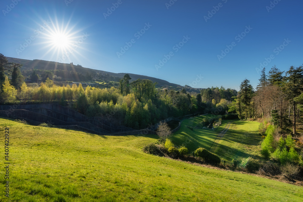 A breathtakingly stunning view showcases lush green hills and vibrant trees basking under the bright sun within a tranquil and peaceful natural setting, Bohernabreena Reservoir, Dublin, Ireland