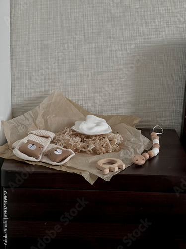 Obraz na płótnie White scratches, beige socks with a bear, wooden beads, a wooden elephant teether are on the bedside table. Aesthetic minimalist baby fashion w salonie