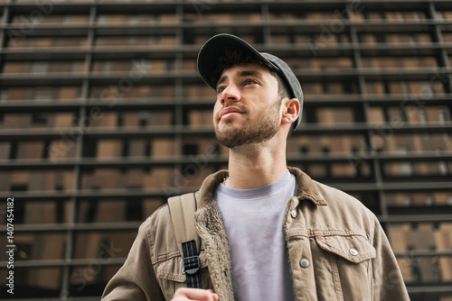 Portrait of a young student wearing cap looking to the side with inspiration in the city 